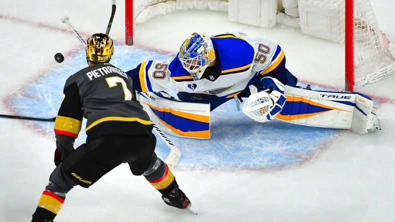 May 7, 2021; Las Vegas, Nevada, USA; St. Louis Blues goaltender Jordan Binnington (50) deflects the puck away from Vegas Golden Knights defenseman Alex Pietrangelo (7) during an overtime period at T-Mobile Arena. Mandatory Credit: Stephen R. Sylvanie-USA TODAY Sports