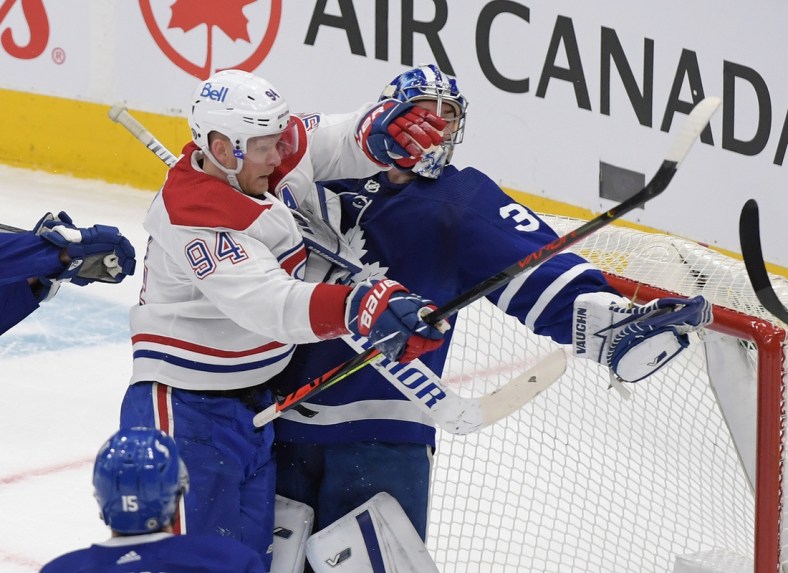 May 8, 2021; Toronto, Ontario, CAN;  Toronto Maple Leafs goalie Jack Campbell (36) holds the puck in his glove as he is bodychecked by Montreal Canadiens forward Corey Perry (94) in the first period at Scotiabank Arena. Mandatory Credit: Dan Hamilton-USA TODAY Sports