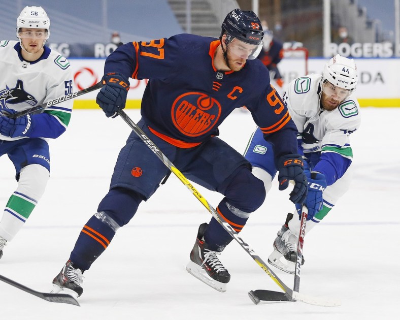 May 8, 2021; Edmonton, Alberta, CAN; Edmonton Oilers forward Connor McDavid (97) battle for the puck against Vancouver Canucks forward Tyler Graovac (44) during the first period at Rogers Place. Mandatory Credit: Perry Nelson-USA TODAY Sports