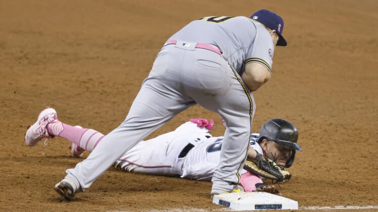 May 9, 2021; Miami, Florida, USA; Miami Marlins Miguel Rojas (bottom) gets picked off at first base by Milwaukee Brewers first baseman Daniel Vogelbach (top) during the fifth inning at loanDepot Park. Mandatory Credit: Rhona Wise-USA TODAY Sports