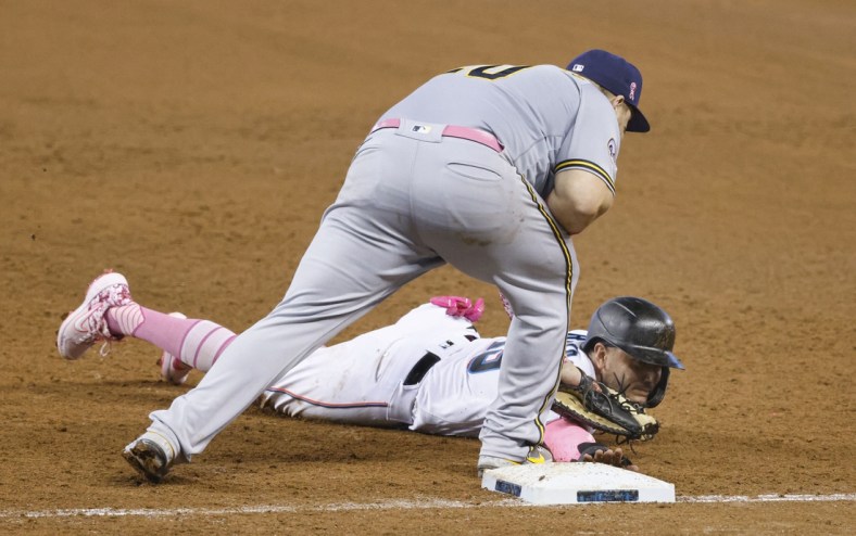 May 9, 2021; Miami, Florida, USA; Miami Marlins Miguel Rojas (bottom) gets picked off at first base by Milwaukee Brewers first baseman Daniel Vogelbach (top) during the fifth inning at loanDepot Park. Mandatory Credit: Rhona Wise-USA TODAY Sports