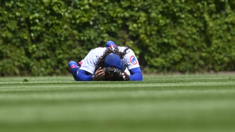 May 9, 2021; Chicago, Illinois, USA;  Chicago Cubs center fielder Jake Marisnick (6) lays on the ground after Pittsburgh Pirates shortstop Wilmer Difo (15)  hit a two RBI single during the first inning at Wrigley Field. Mandatory Credit: Matt Marton-USA TODAY Sports