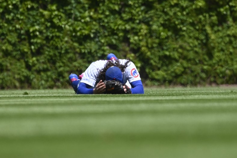 May 9, 2021; Chicago, Illinois, USA;  Chicago Cubs center fielder Jake Marisnick (6) lays on the ground after Pittsburgh Pirates shortstop Wilmer Difo (15)  hit a two RBI single during the first inning at Wrigley Field. Mandatory Credit: Matt Marton-USA TODAY Sports