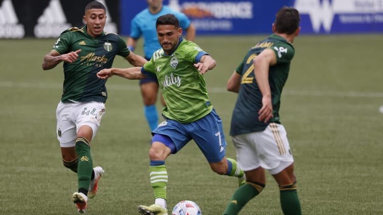 May 9, 2021; Portland, Oregon, USA; Seattle Sounders midfielder Cristian Roldan (7) takes a shot on goal against Portland Timbers midfielder Marvin Lor a (44) during the first half at Providence Park. Mandatory Credit: Soobum Im-USA TODAY Sports