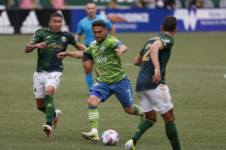 May 9, 2021; Portland, Oregon, USA; Seattle Sounders midfielder Cristian Roldan (7) takes a shot on goal against Portland Timbers midfielder Marvin Lor a (44) during the first half at Providence Park. Mandatory Credit: Soobum Im-USA TODAY Sports