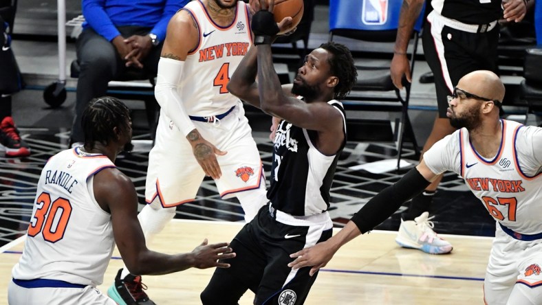 May 9, 2021; Los Angeles, California, USA; LA Clippers guard Patrick Beverley (21) drives to the basket between New York Knicks forward Julius Randle (30), guard Derrick Rose (4) and center Taj Gibson (67) during the first quarter at Staples Center. Mandatory Credit: Robert Hanashiro-USA TODAY Sports