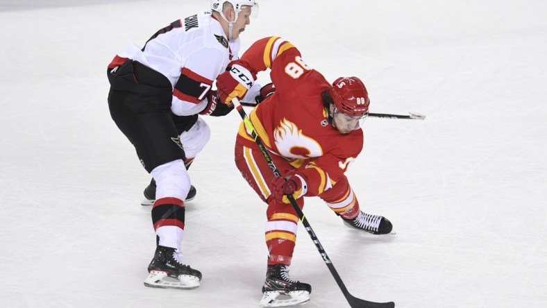 May 9, 2021; Calgary, Alberta, CAN; Calgary Flames forward Andrew Mangiapane (88) battles for the puck with Ottawa Senators forward Brady Tkachuk (7) during the second period at Scotiabank Saddledome. Mandatory Credit: Candice Ward-USA TODAY Sports