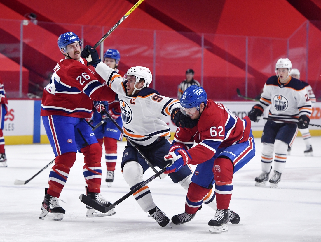 May 10, 2021; Montreal, Quebec, CAN; Edmonton Oilers forward Connor McDavid (97) attempts to go between Montreal Canadiens defenseman Jeff Petry (26) and teammate forward Artturi Lehkonen (62) during the first period at the Bell Centre. Mandatory Credit: Eric Bolte-USA TODAY Sports