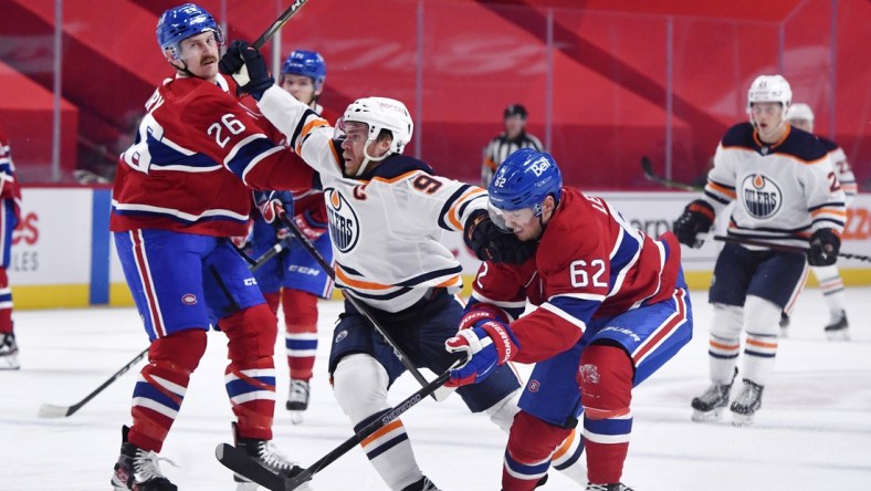 May 10, 2021; Montreal, Quebec, CAN; Edmonton Oilers forward Connor McDavid (97) attempts to go between Montreal Canadiens defenseman Jeff Petry (26) and teammate forward Artturi Lehkonen (62) during the first period at the Bell Centre. Mandatory Credit: Eric Bolte-USA TODAY Sports