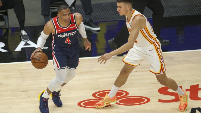 May 10, 2021; Atlanta, Georgia, USA; Washington Wizards guard Russell Westbrook (4) is defended by Atlanta Hawks guard Bogdan Bogdanovic (13) in the first quarter at State Farm Arena. Mandatory Credit: Brett Davis-USA TODAY Sports