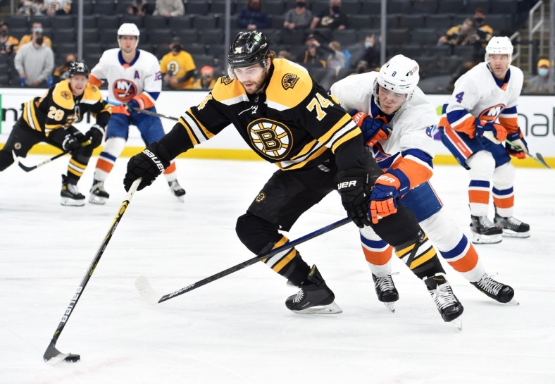 May 10, 2021; Boston, Massachusetts, USA;  Boston Bruins left wing Jake DeBrusk (74) controls the puck ahead of New York Islanders defenseman Noah Dobson (8) during the second period at TD Garden. Mandatory Credit: Bob DeChiara-USA TODAY Sports