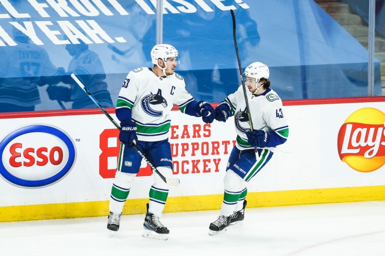 May 10, 2021; Winnipeg, Manitoba, CAN;  Vancouver Canucks forward Bo Horvat (53) is congratulated by Vancouver Canucks defenseman Quinn Hughes (43) on his goal against the Winnipeg Jets during the first period at Bell MTS Place. Mandatory Credit: Terrence Lee-USA TODAY Sports