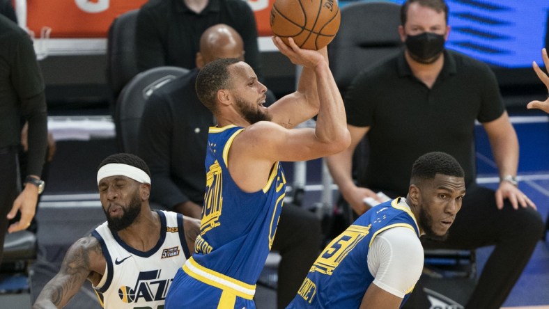 May 10, 2021; San Francisco, California, USA; Golden State Warriors guard Stephen Curry (30) shoots the basketball behind center Kevon Looney (5) against Utah Jazz forward Royce O'Neale (23) during the second quarter at Chase Center. Mandatory Credit: Kyle Terada-USA TODAY Sports