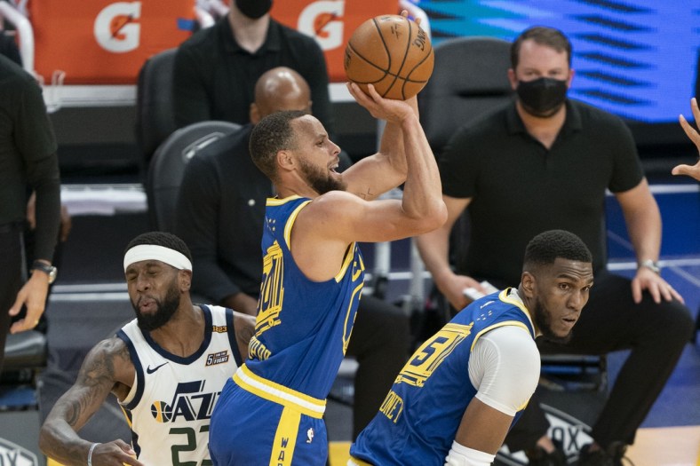 May 10, 2021; San Francisco, California, USA; Golden State Warriors guard Stephen Curry (30) shoots the basketball behind center Kevon Looney (5) against Utah Jazz forward Royce O'Neale (23) during the second quarter at Chase Center. Mandatory Credit: Kyle Terada-USA TODAY Sports
