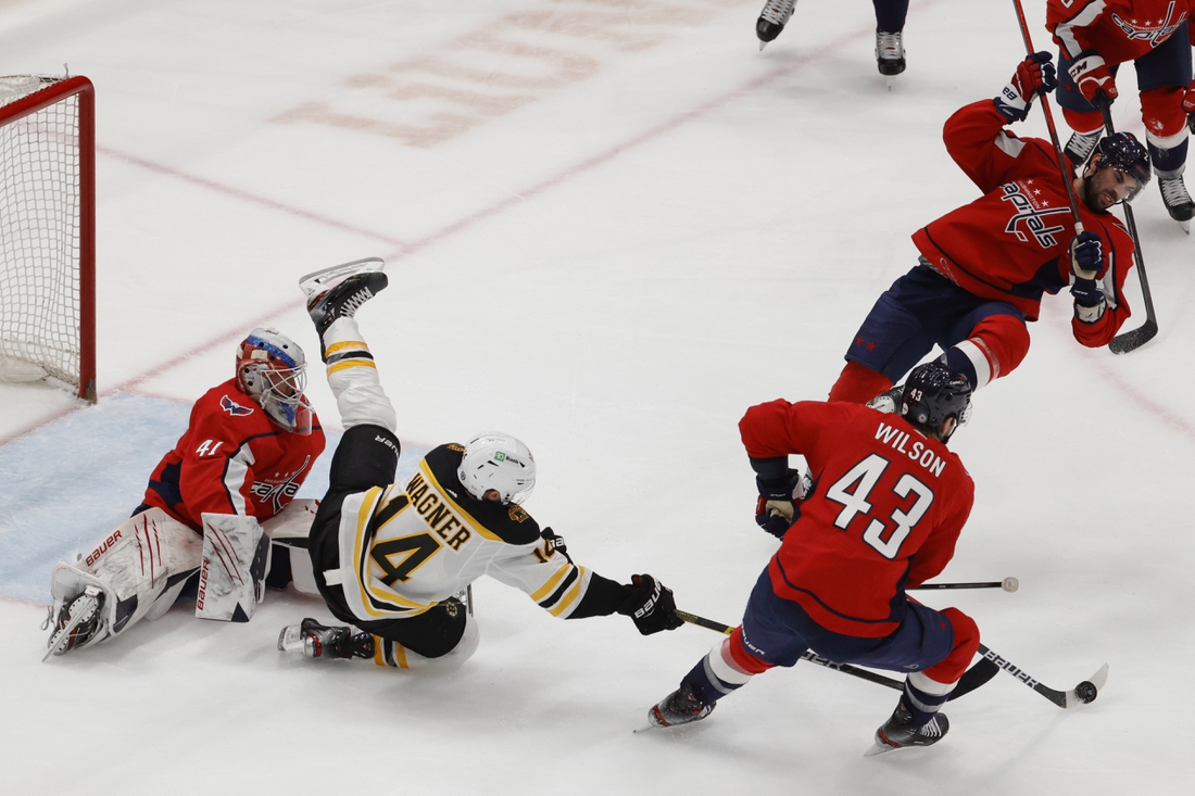 May 11, 2021; Washington, District of Columbia, USA; Boston Bruins right wing Chris Wagner (14) falls over Washington Capitals goaltender Vitek Vanecek (41) while Capitals right wing Tom Wilson (43) controls the puck in the second period at Capital One Arena. Mandatory Credit: Geoff Burke-USA TODAY Sports