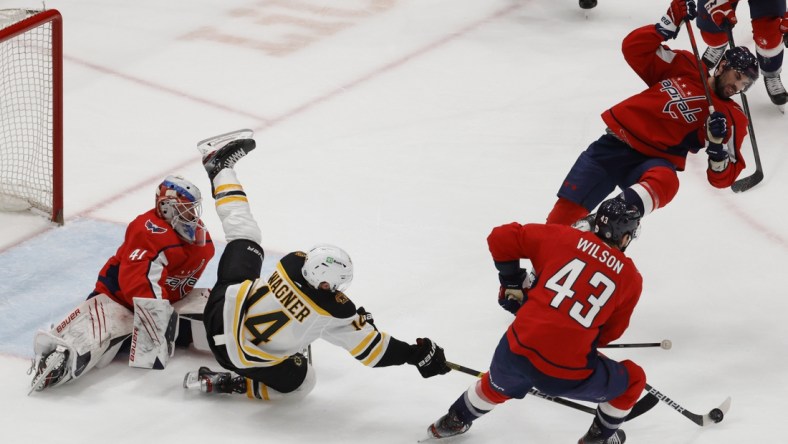 May 11, 2021; Washington, District of Columbia, USA; Boston Bruins right wing Chris Wagner (14) falls over Washington Capitals goaltender Vitek Vanecek (41) while Capitals right wing Tom Wilson (43) controls the puck in the second period at Capital One Arena. Mandatory Credit: Geoff Burke-USA TODAY Sports