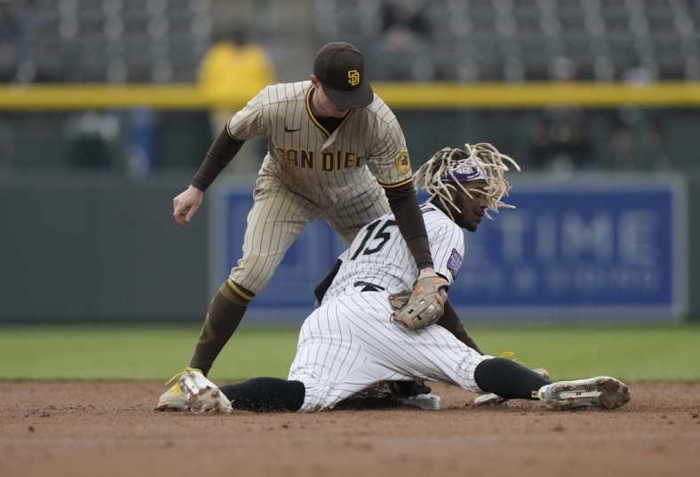 May 11, 2021; Denver, Colorado, USA; Colorado Rockies left fielder Raimel Tapia (15) slides safety under the tag of San Diego Padres second baseman Jake Cronenworth (9) in the first inning at Coors Field. Mandatory Credit: Ron Chenoy-USA TODAY Sports