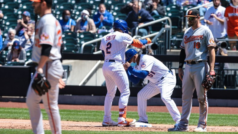 May 12, 2021; New York City, New York, USA; New York Mets first baseman Dominic Smith (2) reacts with first base coach Tony Tarasco (51) after hitting an RBI single against Baltimore Orioles starting pitcher Matt Harvey (32) during the fifth inning at Citi Field. Mandatory Credit: Vincent Carchietta-USA TODAY Sports