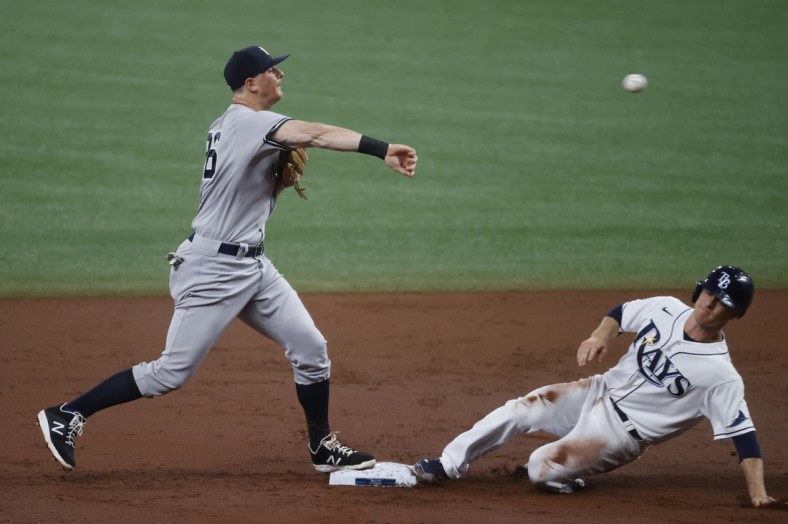 May 12, 2021; St. Petersburg, Florida, USA; New York Yankees second baseman DJ LeMahieu (26) forces out Tampa Bay Rays third baseman Joey Wendle (18) as he throws the ball to first base for a double play during the second inning at Tropicana Field. Mandatory Credit: Kim Klement-USA TODAY Sports