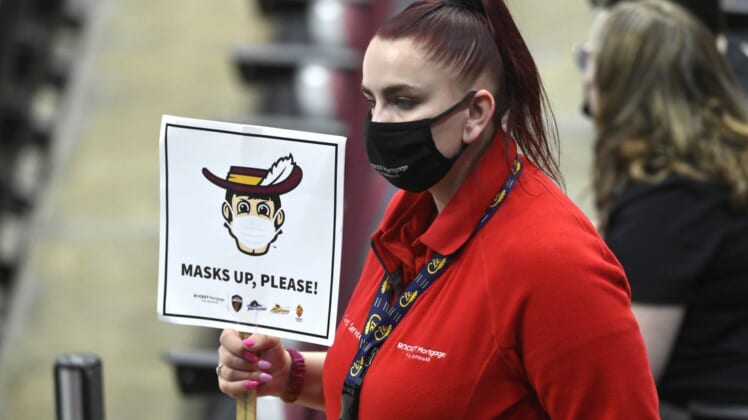 May 12, 2021; Cleveland, Ohio, USA; An arena usher holds a mask sign in the third quarter of a game between the Cleveland Cavaliers and the Boston Celtics at Rocket Mortgage FieldHouse. Mandatory Credit: David Richard-USA TODAY Sports