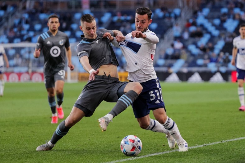 May 12, 2021; Saint Paul, MN, USA; Minnesota United midfielder Jan Gregus (8) defends Vancouver Whitecaps forward Russell Teibert (31) in the first half at Allianz Field. Mandatory Credit: Brad Rempel-USA TODAY Sports