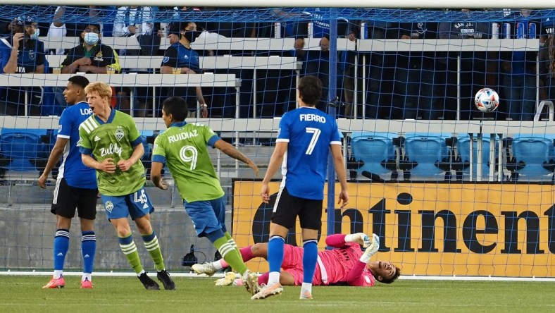 May 12, 2021; San Jose, California, USA; San Jose Earthquakes goalkeeper JT Marcinkowski (1) lays on the ground as Seattle Sounders FC players celebrate a goal during the first half at PayPal Park. Mandatory Credit: Kelley L Cox-USA TODAY Sports