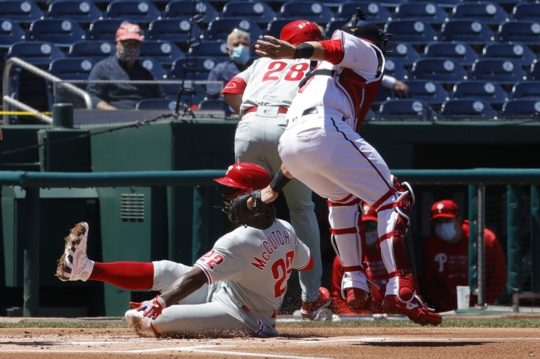 May 13, 2021; Washington, District of Columbia, USA; Philadelphia Phillies center fielder Andrew McCutchen (22) scores a run ahead of the tag of Washington Nationals catcher Yan Gomes (10) in the first inning at Nationals Park. Mandatory Credit: Geoff Burke-USA TODAY Sports