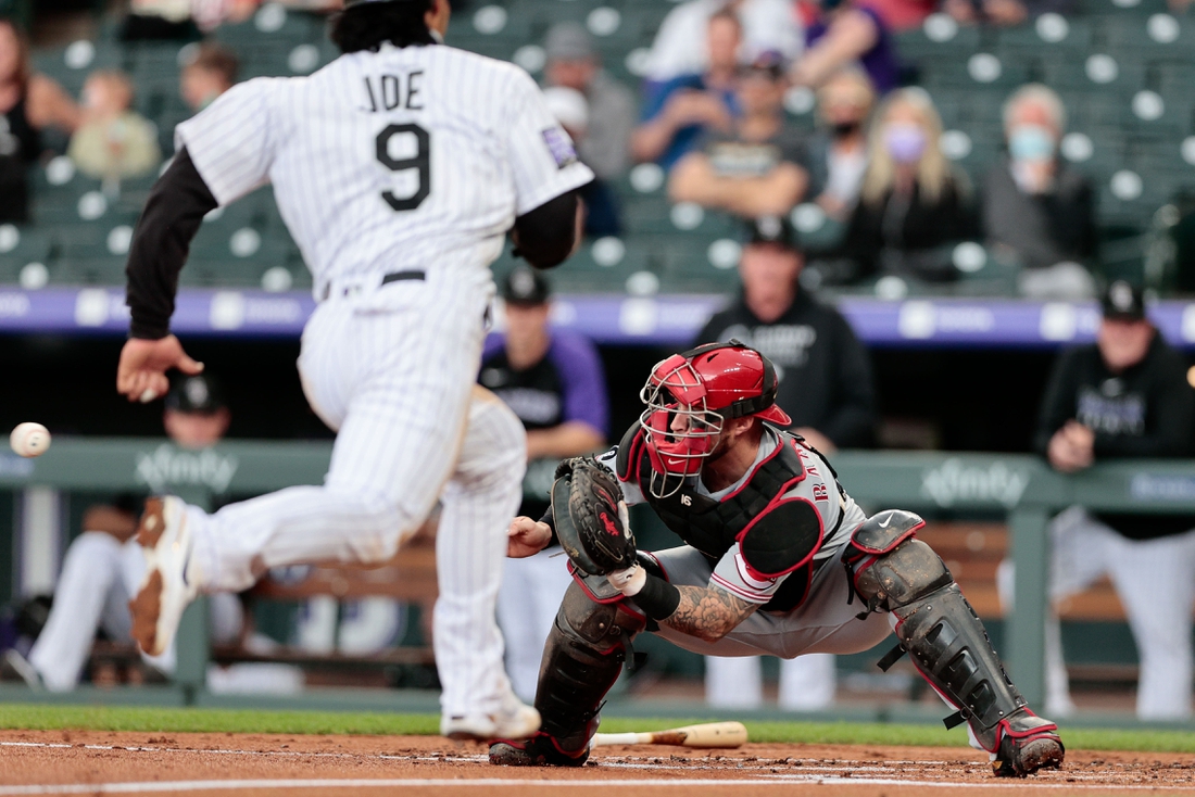 May 13, 2021; Denver, Colorado, USA; Cincinnati Reds catcher Tucker Barnhart (16) fields a throw as Colorado Rockies first baseman Connor Joe (9) runs towards home plate during the first inning at Coors Field. Mandatory Credit: Isaiah J. Downing-USA TODAY Sports