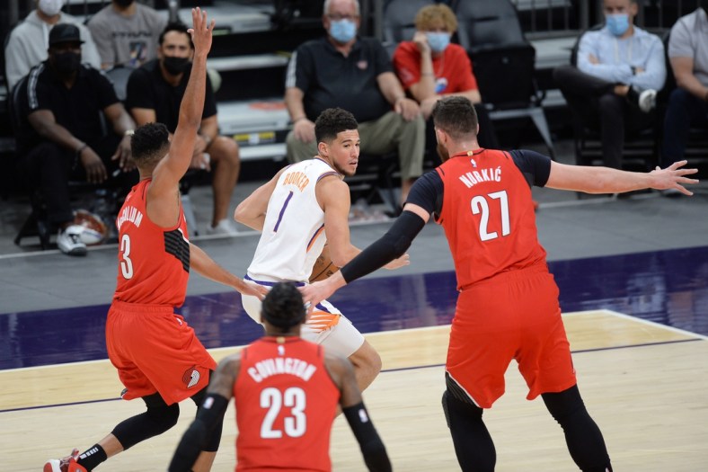 May 13, 2021; Phoenix, Arizona, USA; Phoenix Suns guard Devin Booker (1) controls the ball against Portland Trail Blazers defenders during the first half at Phoenix Suns Arena. Mandatory Credit: Joe Camporeale-USA TODAY Sports