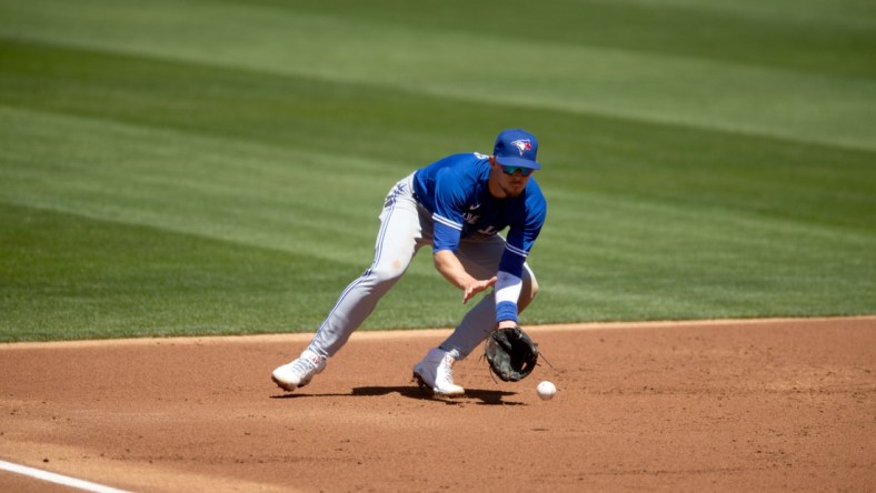 May 6, 2021; Oakland, California, USA; Toronto Blue Jays third baseman Cavan Biggio fields a ground ball by Oakland Athletics right fielder Stephen Piscotty during the second inning at RingCentral Coliseum. Mandatory Credit: D. Ross Cameron-USA TODAY Sports