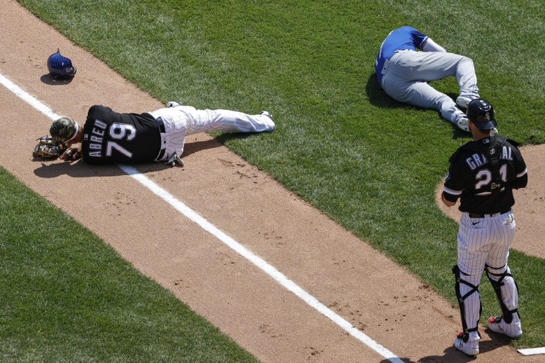 May 14, 2021; Chicago, Illinois, USA; Chicago White Sox first baseman Jose Abreu (79) and Kansas City Royals third baseman Hunter Dozier (17) lay on the field after colliding along the first base line during the second inning of the first game of a doubleheader at Guaranteed Rate Field. Mandatory Credit: Kamil Krzaczynski-USA TODAY Sports