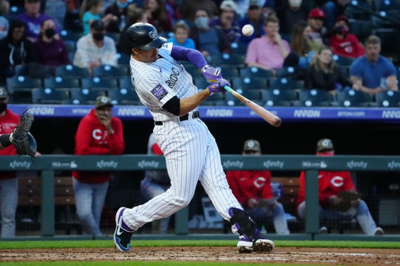 May 14, 2021; Denver, Colorado, USA; Colorado Rockies third baseman Josh Fuentes (8) hits an RBI single in the third inning against the Cincinnati Reds at Coors Field. Mandatory Credit: Ron Chenoy-USA TODAY Sports
