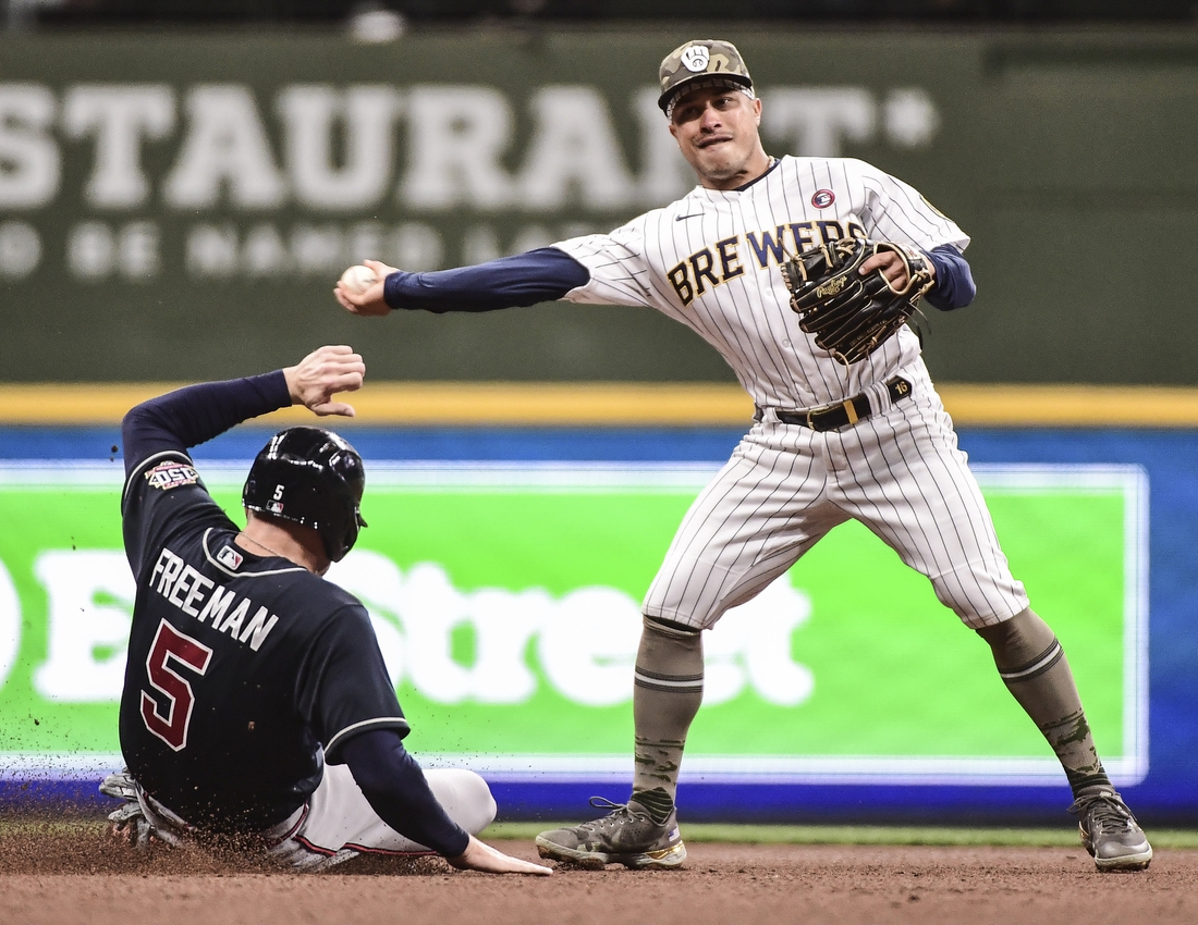 May 15, 2021; Milwaukee, Wisconsin, USA; Atlanta Braves first baseman Freddie Freeman (5) breaks up a double play attempt by Milwaukee Brewers second baseman Kolten Wong (16) in the fourth inning at American Family Field. Mandatory Credit: Benny Sieu-USA TODAY Sports