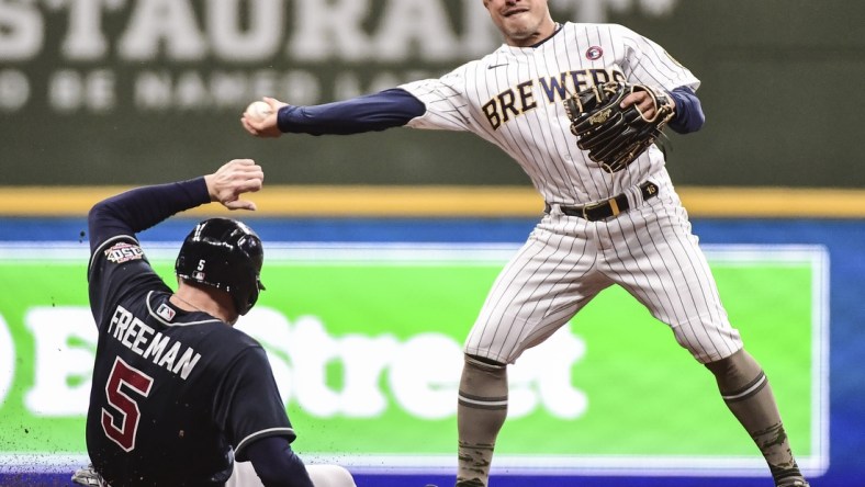 May 15, 2021; Milwaukee, Wisconsin, USA; Atlanta Braves first baseman Freddie Freeman (5) breaks up a double play attempt by Milwaukee Brewers second baseman Kolten Wong (16) in the fourth inning at American Family Field. Mandatory Credit: Benny Sieu-USA TODAY Sports