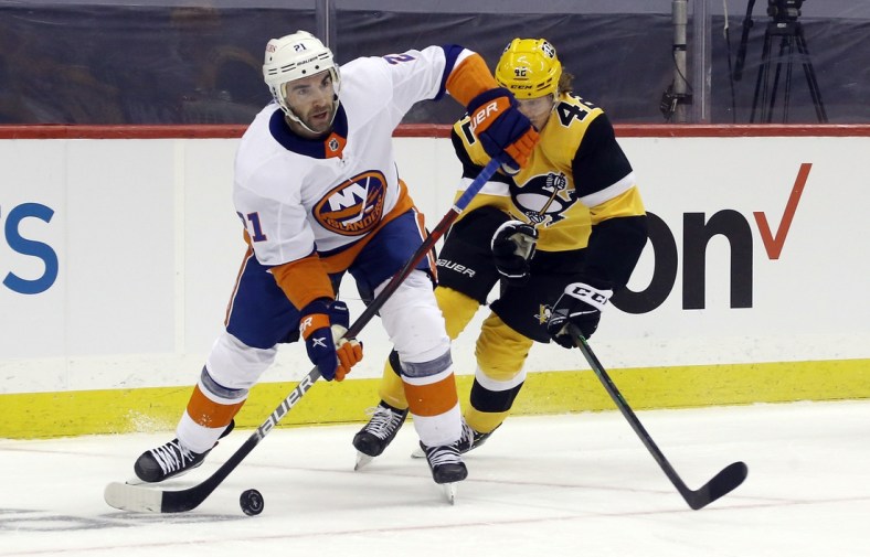 May 16, 2021; Pittsburgh, Pennsylvania, USA; New York Islanders right wing Kyle Palmieri (21) moves the puck against Pittsburgh Penguins right wing Kasperi Kapanen (42) during the first period in game one of the first round of the 2021 Stanley Cup Playoffs at PPG Paints Arena. Mandatory Credit: Charles LeClaire-USA TODAY Sports