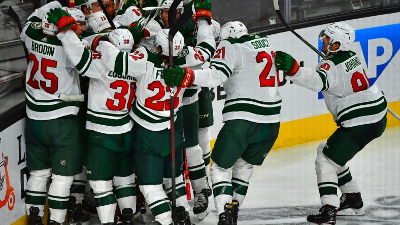 May 16, 2021; Las Vegas, Nevada, USA; Minnesota Wild players celebrate after Minnesota Wild center Joel Eriksson Ek (14) scored an overtime goal to defeat the Vegas Golden Knights 1-0 in game one of the first round of the 2021 Stanley Cup Playoffs at T-Mobile Arena. Mandatory Credit: Stephen R. Sylvanie-USA TODAY Sports