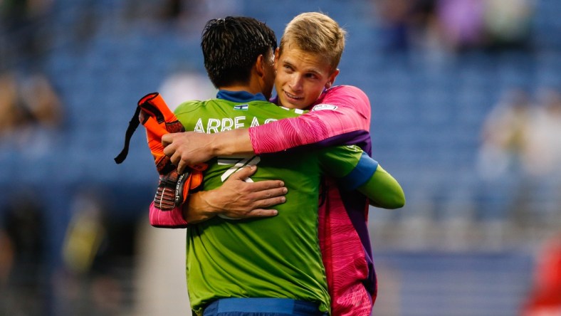 May 16, 2021; Seattle, Washington, USA; Seattle Sounders FC defender Xavier Arreaga (3) hugs goalkeeper Stefan Cleveland (30) after a win against the Los Angeles FC during the second half at Lumen Field. Mandatory Credit: Jennifer Buchanan-USA TODAY Sports