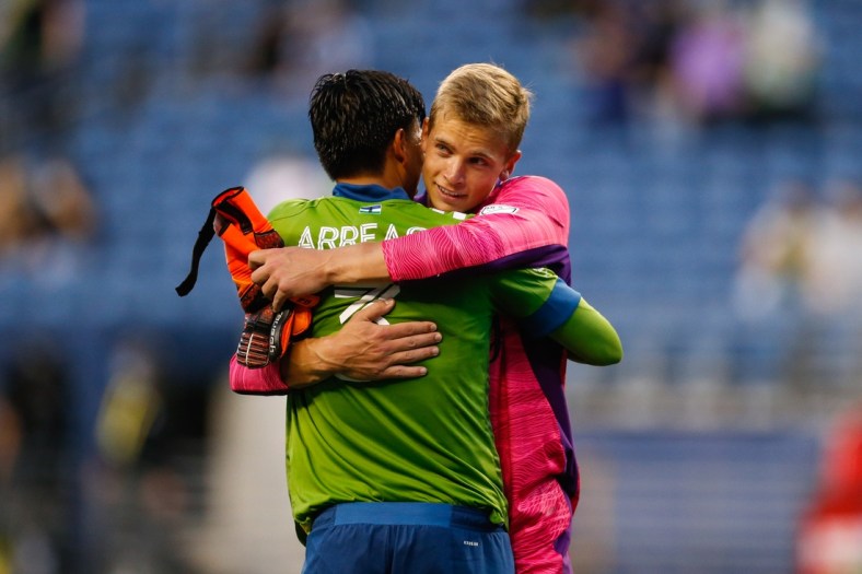 May 16, 2021; Seattle, Washington, USA; Seattle Sounders FC defender Xavier Arreaga (3) hugs goalkeeper Stefan Cleveland (30) after a win against the Los Angeles FC during the second half at Lumen Field. Mandatory Credit: Jennifer Buchanan-USA TODAY Sports