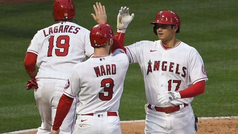 May 17, 2021; Anaheim, California, USA; Los Angeles Angels designated hitter Shohei Ohtani (17) is congratulated by right fielder Taylor Ward (3) and left fielder Juan Lagares (19) after hitting a two-run home run against the Cleveland Indians during the second inning at Angel Stadium. Mandatory Credit: Richard Mackson-USA TODAY Sports