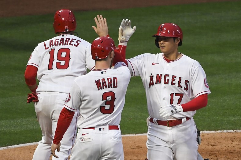 May 17, 2021; Anaheim, California, USA; Los Angeles Angels designated hitter Shohei Ohtani (17) is congratulated by right fielder Taylor Ward (3) and left fielder Juan Lagares (19) after hitting a two-run home run against the Cleveland Indians during the second inning at Angel Stadium. Mandatory Credit: Richard Mackson-USA TODAY Sports