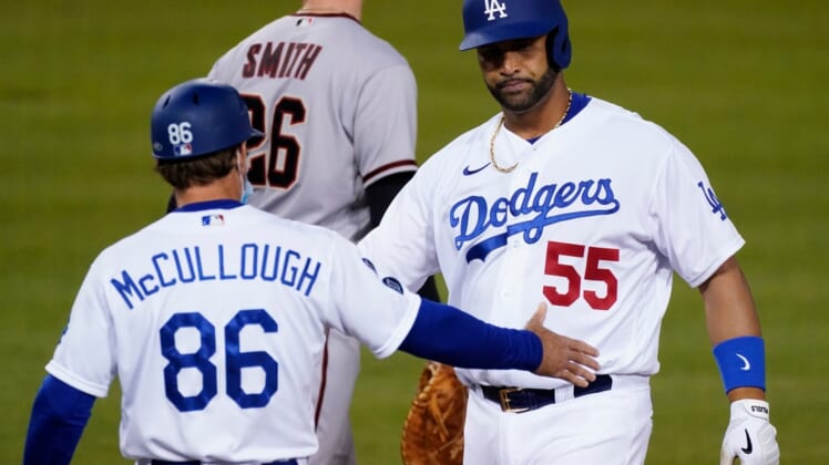 May 17, 2021; Los Angeles, California, USA; Los Angeles Dodgers first baseman Albert Pujols (55) is congratulated by first base coach Clayton McCullough after singling in a run against the Arizona Diamondbacks in the third inning at Dodger Stadium. Mandatory Credit: Robert Hanashiro-USA TODAY Sports