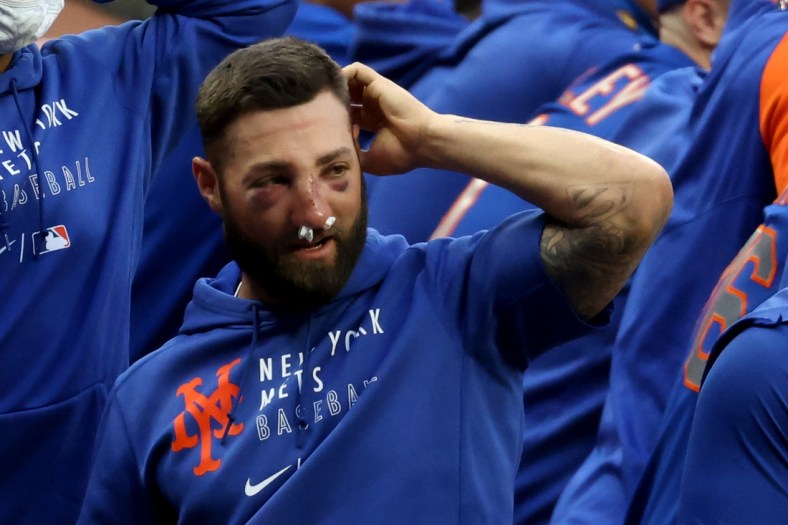 May 18, 2021; Atlanta, Georgia, USA; New York Mets outfielder Kevin Pillar supports teammates after he was hit in the face with a ball suffering a nasal fracture the night before against the Atlanta Braves at Truist Park. Mandatory Credit: Jason Getz-USA TODAY Sports