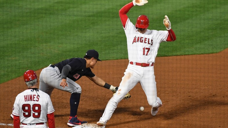 May 18, 2021; Anaheim, California, USA; Los Angeles Angels designated hitter Shohei Ohtani (17) is safe at first base against Cleveland Indians shortstop Yu Chang (2) in the fourth inning at Angel Stadium. Mandatory Credit: Richard Mackson-USA TODAY Sports