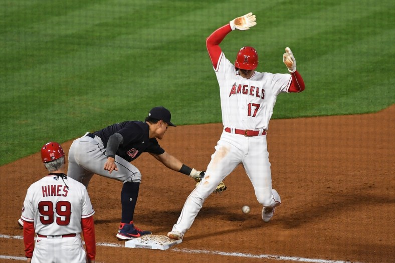May 18, 2021; Anaheim, California, USA; Los Angeles Angels designated hitter Shohei Ohtani (17) is safe at first base against Cleveland Indians shortstop Yu Chang (2) in the fourth inning at Angel Stadium. Mandatory Credit: Richard Mackson-USA TODAY Sports