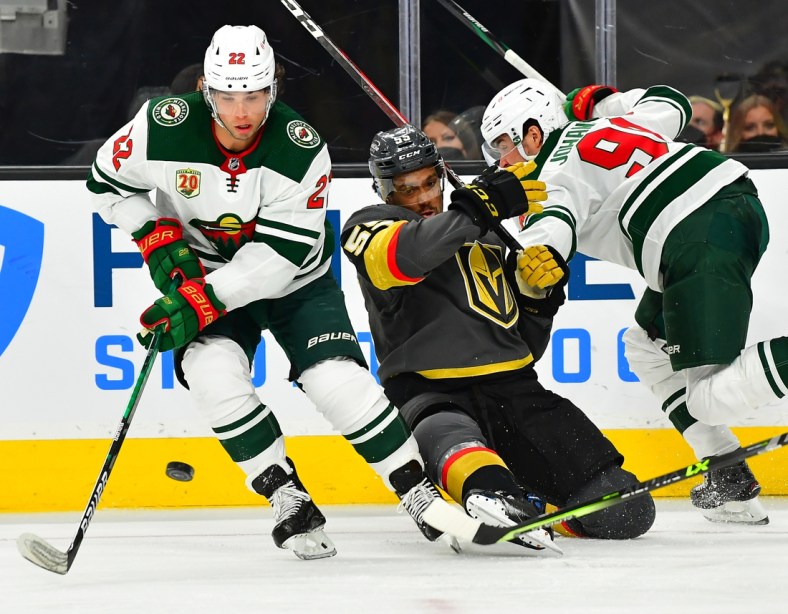 May 18, 2021; Las Vegas, Nevada, USA; Vegas Golden Knights right wing Keegan Kolesar (55) is hit by Minnesota Wild center Marcus Johansson (90) as Minnesota Wild left wing Kevin Fiala (22) chips the puck away during the second period of game two of the first round of the 2021 Stanley Cup Playoffs at T-Mobile Arena. Mandatory Credit: Stephen R. Sylvanie-USA TODAY Sports