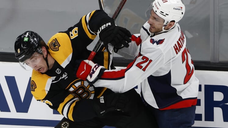 May 19, 2021; Boston, Massachusetts, USA; Washington Capitals right wing Garnet Hathaway (21) checks Boston Bruins defenseman Mike Reilly (6) during the first period in game three of the first round of the 2021 Stanley Cup Playoffs at TD Garden. Mandatory Credit: Winslow Townson-USA TODAY Sports