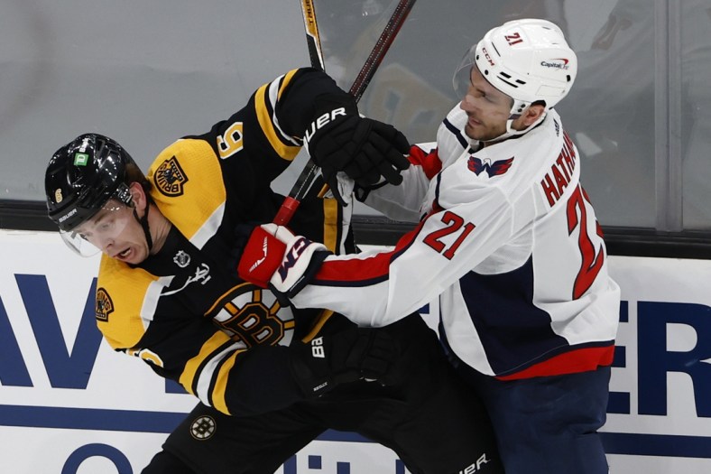 May 19, 2021; Boston, Massachusetts, USA; Washington Capitals right wing Garnet Hathaway (21) checks Boston Bruins defenseman Mike Reilly (6) during the first period in game three of the first round of the 2021 Stanley Cup Playoffs at TD Garden. Mandatory Credit: Winslow Townson-USA TODAY Sports