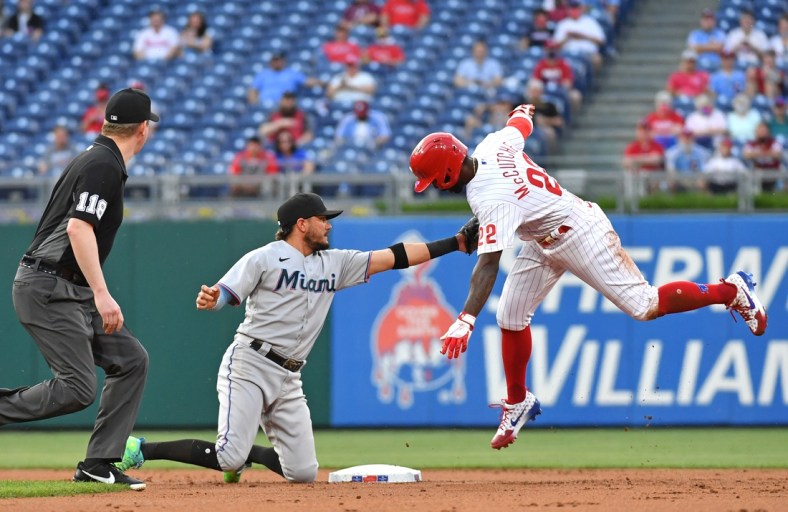 May 19, 2021; Philadelphia, Pennsylvania, USA;  Miami Marlins shortstop Miguel Rojas (19) tags out Philadelphia Phillies center fielder Andrew McCutchen (22) during the first inning at Citizens Bank Park. Mandatory Credit: Eric Hartline-USA TODAY Sports