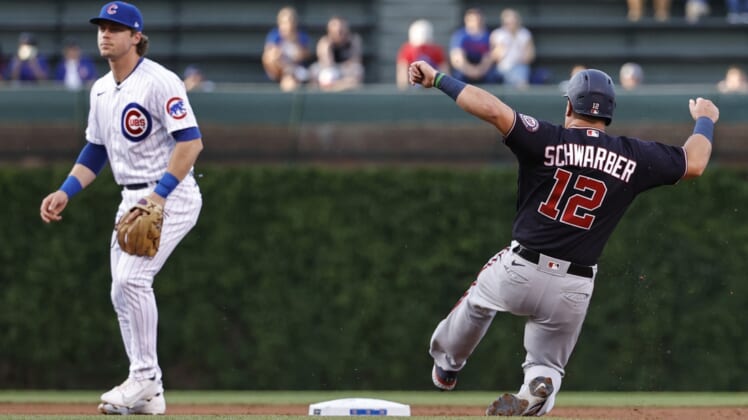 May 19, 2021; Chicago, Illinois, USA; Washington Nationals left fielder Kyle Schwarber (12) steals second base as Chicago Cubs shortstop Nico Hoerner (2) waits for the ball during the second inning at Wrigley Field. Mandatory Credit: Kamil Krzaczynski-USA TODAY Sports