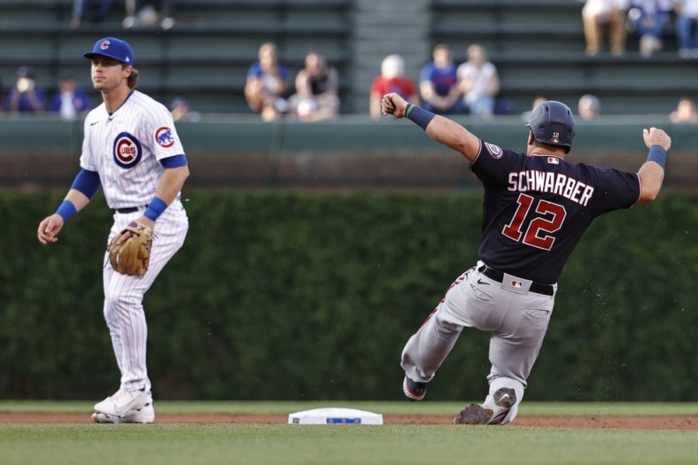 May 19, 2021; Chicago, Illinois, USA; Washington Nationals left fielder Kyle Schwarber (12) steals second base as Chicago Cubs shortstop Nico Hoerner (2) waits for the ball during the second inning at Wrigley Field. Mandatory Credit: Kamil Krzaczynski-USA TODAY Sports